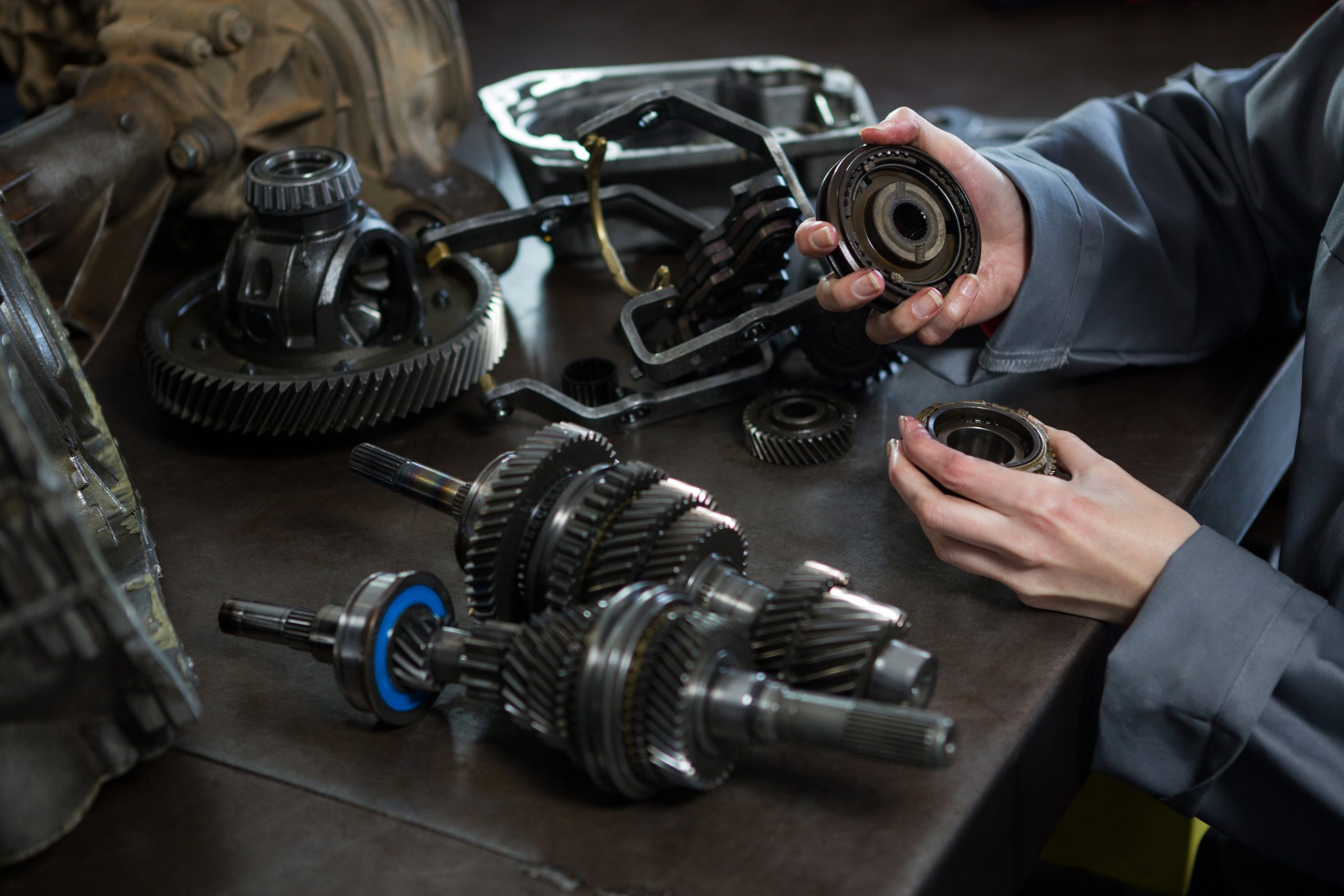 Mechanic inspecting transmission parts during vehicle repair